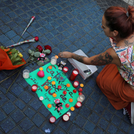 Una mujer coloca velas y un cartel que reza: "Catalunya, lugar de paz" en la zona del atentado REUTERS/Sergio Perez
