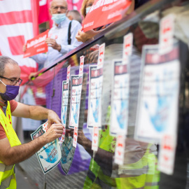 Persona pegando carteles en la manifestación contra el ERE del banco Sabadell