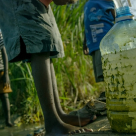 En la imagen, niños de Owino Uhuru, un asentamiento chabolista de Mobasa (Kenia), recogen agua aún contaminada por los vertidos de plomo de una empresa de reciclaje de baterías de coche que fue cerrada después de que murieran y enfermaran numerosos ha