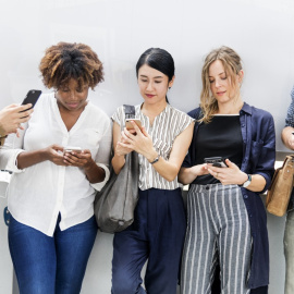 Un grupo de jóvenes absortos con sus móviles.