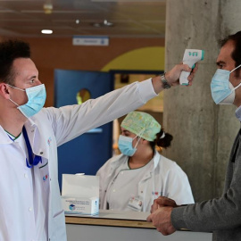 Un sanitario toma la temperatura a un hombre que accede al Hospital de Alcorcón en Madrid, este lunes. EFE/Víctor Lerena
