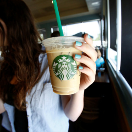 Una mujer sostiene una bebida en una cafetería Starbucks. / REUTERS - Mario Anzuoni
