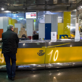 16/03/2021. Imagen de archivo de un cliente siendo atendido en una oficina de Correos, en Madrid. - EUROPA PRESS