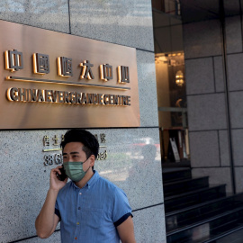 Un hombre hablando por su móvil pasa por delante del edificio China Evergrande Centre, en Hong Kong. EFE/EPA/JEROME FAVRE