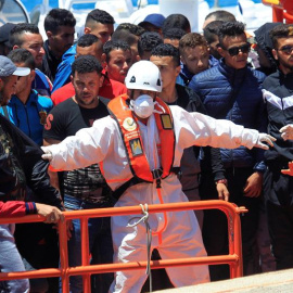 Un operario de Salvamento Marítimo controla la bajada de los setenta inmigrantes rescatados hoy en aguas del estrecho de Gibraltar cuando viajaban en una patera y que han sido trasladados al puerto de Tarifa (Cádiz). EFE/A.Carrasco Ragel