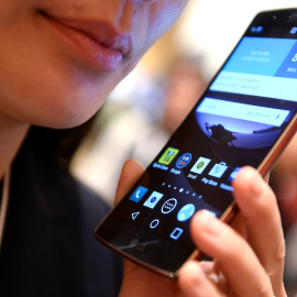 Una mujer utiliza su teléfono móvil.