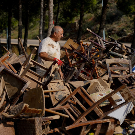 Un hombre entre mobiliario afectado tras el paso de la DANA.