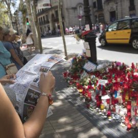 Una joven consulta un plano ante una de las ofrendas en las Ramblas cuatro días después de los atentados. EFE/Marta Pérez