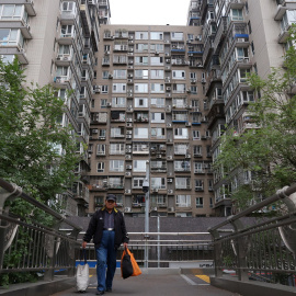 Un hombre cruzo un puente cerca de un edificio residencial en Pekín. REUTERS/Florence Lo
