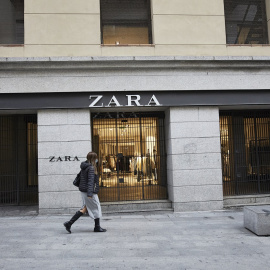 Una mujer pasa al lado del primer local de Zara que abrió en Madrid, junto a la Puerta del Sol, y que ha echado el cierre en noviembre.