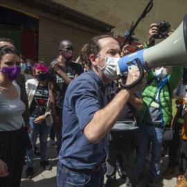 La ministra de Igualdad y el candidato de Unidas Podemos a la Presidencia de la Comunidad, Pablo Iglesias con un megáfono se dirige al público durante un acto del partido en el Polideportivo municipal Cerro Buenavista de Getafe, a 27 de abril de 2021, e
