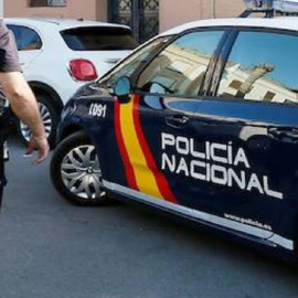 Imagen de archivo de un agente y un coche de la Policía Nacional. - EFE