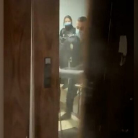 Los policías intentando entrar en la vivienda madrileña.