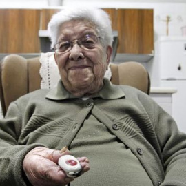 Una persona mayor, con el dispositivo de aviso usado por el Servicio de Teleasistencia.