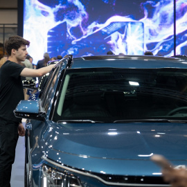 Un joven frente a un vehículo en una imagen de archivo tomada antes del inicio del Automobile Barcelona 2023, a 11 de mayo de 2023
