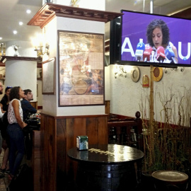 La secretaria general de Podemos Euskadi, Nagua Alba (3i), sigue en un bar cercano a la sede del partido en Vitoria las noticias sobre su anuncio de no presentarse a la reelección en las primarias que se celebrarán próximamente. EFE/David Aguilar