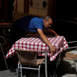 Un camarero coloca una mesa en una terraza en el centro de Madrid. REUTERS