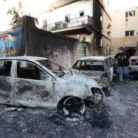 05/07/2023 - Un palestino inspecciona los vehículos destruidos después de una redada del ejército israelí en la ciudad cisjordana de Yenín, a 5 de julio de 2023.