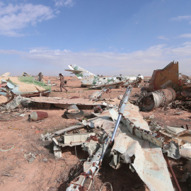 Un miliciano de las Fuerzas de Siria Democrática pasa junto a los restos de aviones destruidos ne la ciudad de Raqqa. - REUTERS