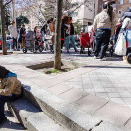 Un grupo de persona espera una cola durante la entrega de ropa de abrigo y zapatos nuevos a niños vulnerables, a 24 de febrero de 2023, en Madrid (España).