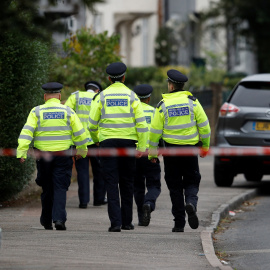 Policías caminan detrás del cordón de seguridad instalado en las casa del segundo sospechosos detenido en relación con el atentado en el metro de Londres. REUTERS/Peter Nicholls