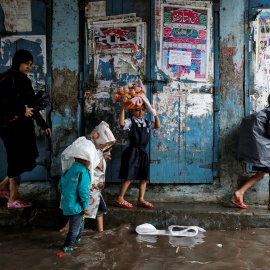 Unos niños se dirigen a la escuela tras las grandes inundaciones que ha sufrido Mumbai, en la India/REUTERS