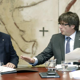 El presidente de la Generalitat, Carles Puigdemont, y el vicepresidente del Govern, Oriol Junqueras (i), hoy durante la reunión semanal del Govern, un día después de presentarse la futura ley de Transitoriedad Jurídica, que marca el camino del pulso s