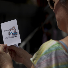 Una dona mira el recordatori del funeral