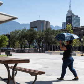 28/06/2023 - Una mujer sostiene una sombrilla para protegerse del sol debido a las altas temperaturas.