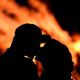 Una pareja se besa delante de una hoguera durante la tradicional noche de San Juan en Gijó. REUTERS / Eloy Alonso