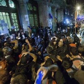 La Guardia Civil sale de la Conselleria d'Economia rodeada de manifestantes. / EFE