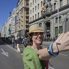 Una mujer se hace una fotografía en la Gran Vía de Madrid cerrada al tráfico con motivo del Día Sin Coches que, además de Madrid, celebran Valladolid, San Sebastián, y Valencia, entre 330 ciudades, con acciones que van desde limitar el tráfico priv