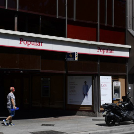 Un hombre pasa junto a una oficina del Banco Popular en  Madrid. AFP/Pierre-Philippe Marcou