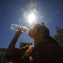 31/07/2023.-Una mujer se refresca bebiendo agua en el centro de Córdoba donde se ha dado aviso naranja por altas temperaturas.