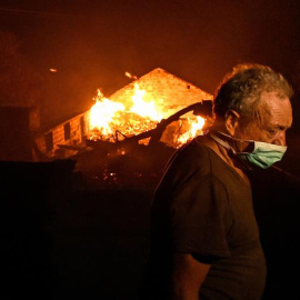 Un hombre entre las llamas en un incendio forestal declarado en Adica, Tondela (Portugal). / EFE
