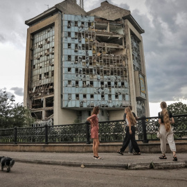 Varias personas pasan frente a un edificio destruido en un ataque ruso con drones en Izmail, en la región ucraniana de Odesa, a 2 de agosto de 2023