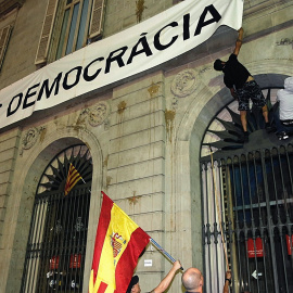 Dos personas intentan arrancar la pancarta de "Mès Democràcia" colgada en el ayuntamiento de Barcelona EFE/Juan Carlos Cárdenas
