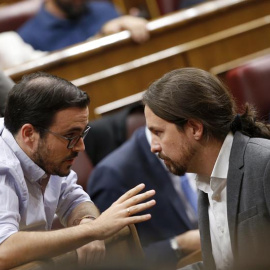 El secretario general de Podemos, Pablo Iglesias (d), conversa con el coordinador general de IU, Alberto Garzón (i). /EFE
