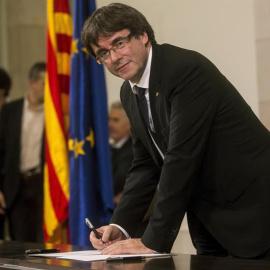 Puigdemont firma el documento de adhesión a la República catalana después de comparecer ante el pleno del Parlament para trasladar los resultados de la jornada del 1-O. | QUIQUE GARCÍA (EFE)