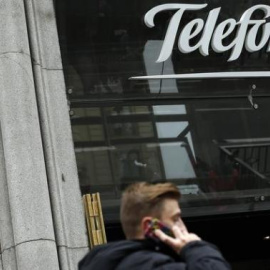 Un hombre habla con su móvil delante de la sede de Telefónica en la Gran Vía madrileña. REUTERS