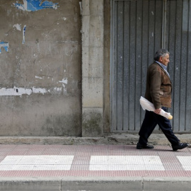 Un pensionistas camina por una calle del pueblo burgalés de  Briviesca. AFP / César Manso