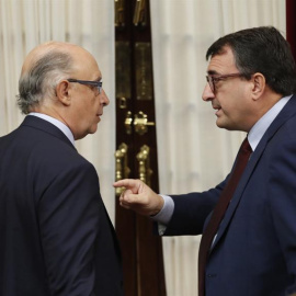 El ministro de Hacienda, Cristóbal Montoro, y el portavoz parlamentario del PNV, Aitor Esteban, dirimen diferencias durante la última sesión de control al Ejecutivo. /EFE