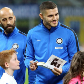 El capitán del Inter de Milán, Mauro Icardi, firma una copia de "El diario de Ana Frank" para un niño antes de un partido de la Serie A italiana entre el Inter de Milán y el UC Sampdoria. /EFE