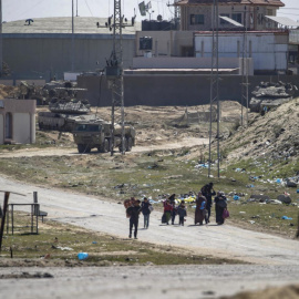 Tanques israelíes patrulla mientras los palestinos desplazados internos caminan hacia Rafah.