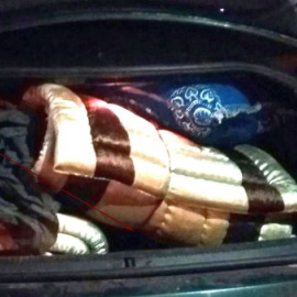 Imagen facilitada por la Policía del maletero del coche en el que iban escondidos dos jóvenes migrantes.