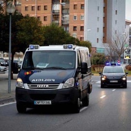 El coche y el furgón de la Policía que conduce a la manada al Palacio de Justica de Navarra. | EFE
