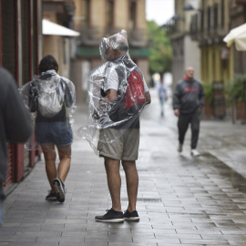 Varias personas caminan bajo la lluvia, a 2 de septiembre de 2023, en Huesca, Aragón (España).