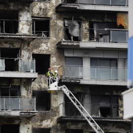 Bomberos trabajan en la limpieza del edificio incendiado, en el barrio de Campanar, a 27 de febrero de 2024, en València, País Valencià.