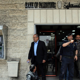 Un policía de Hamás gesticula ante la entrada de un banco en la ciudad de Gaza. | (REUTERS/Ibraheem Abu Mustafa)
