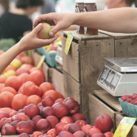 Una mujer compra en un puesto de frutas en un mercado. E.P.